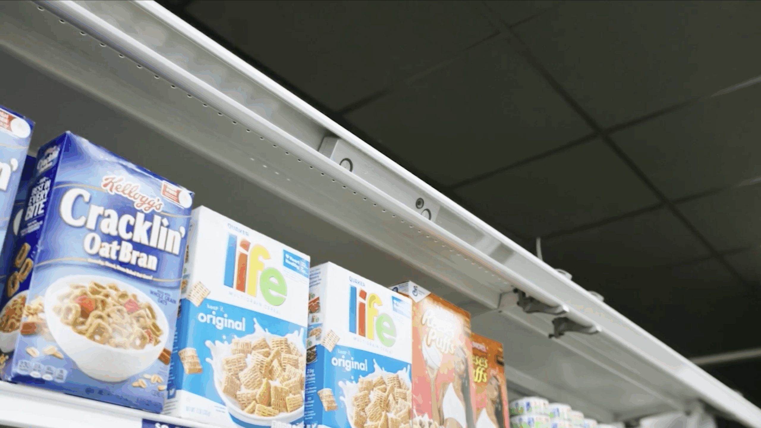 Rovr Invisible Robot by Spacee and SPAR in track on shelf for demonstration above cereal